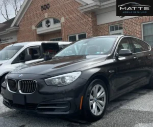 A close-up front angle of a shiny, dark grey BMW sedan showing a high-gloss finish after a professional detailing service.